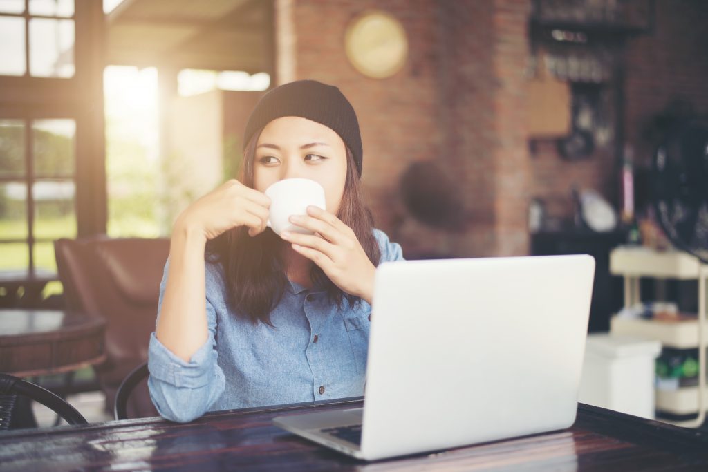 Beautiful young hipster woman sitting in a coffee shop, relax an